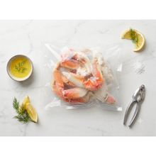 Load image into Gallery viewer, Frozen Dungeness crab sections in vacuum-sealed bag with butter and lemon
