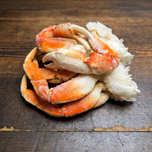 Load image into Gallery viewer, Close-up of frozen Dungeness crab claws and legs on rustic wood
