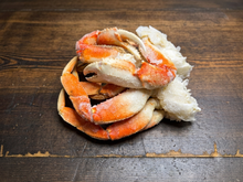Load image into Gallery viewer, Close-up of frozen Dungeness crab claws and legs on rustic wood
